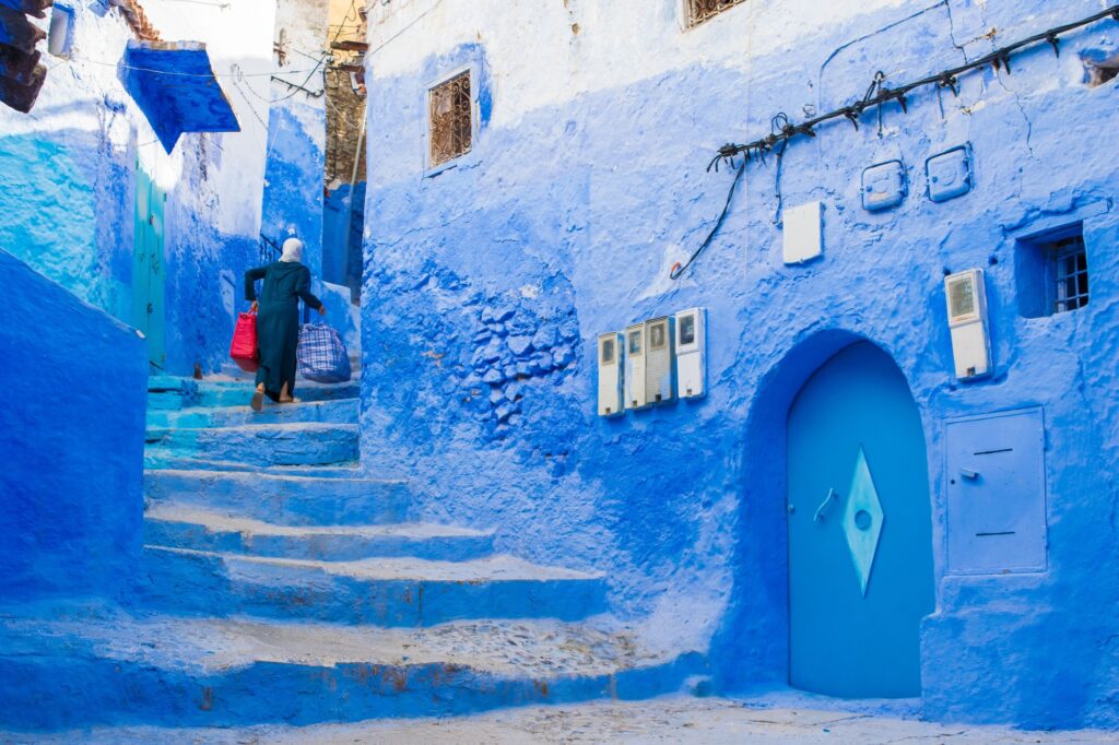 Narrow street with blue painted walls and stairs in the medina of city of Chefchaouen, Morocco.