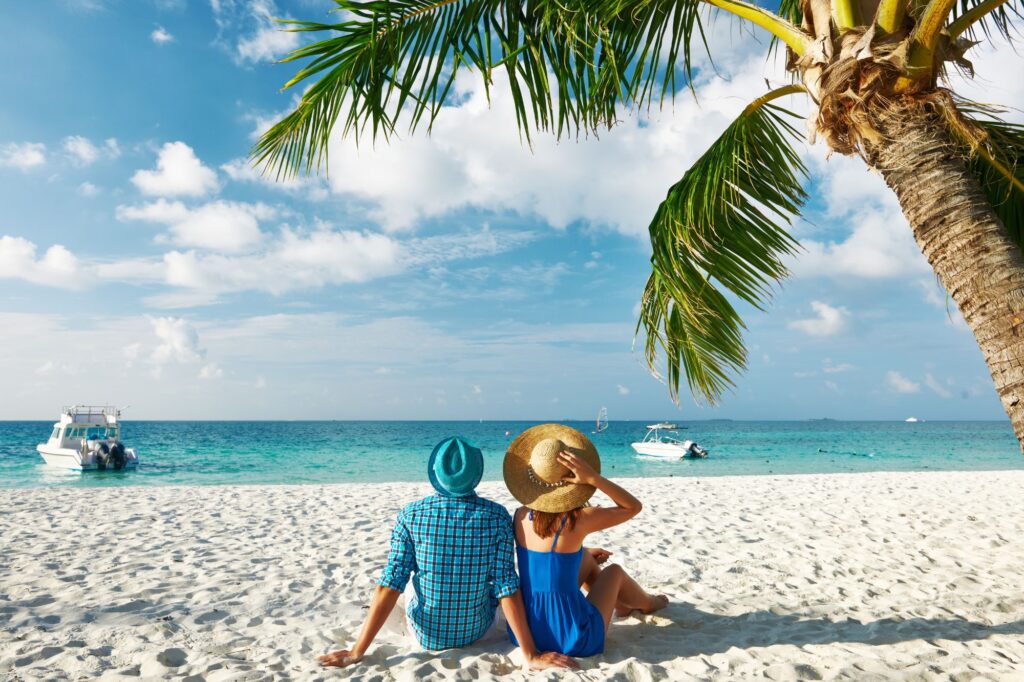 Couple sitting on the beach in the Maldives