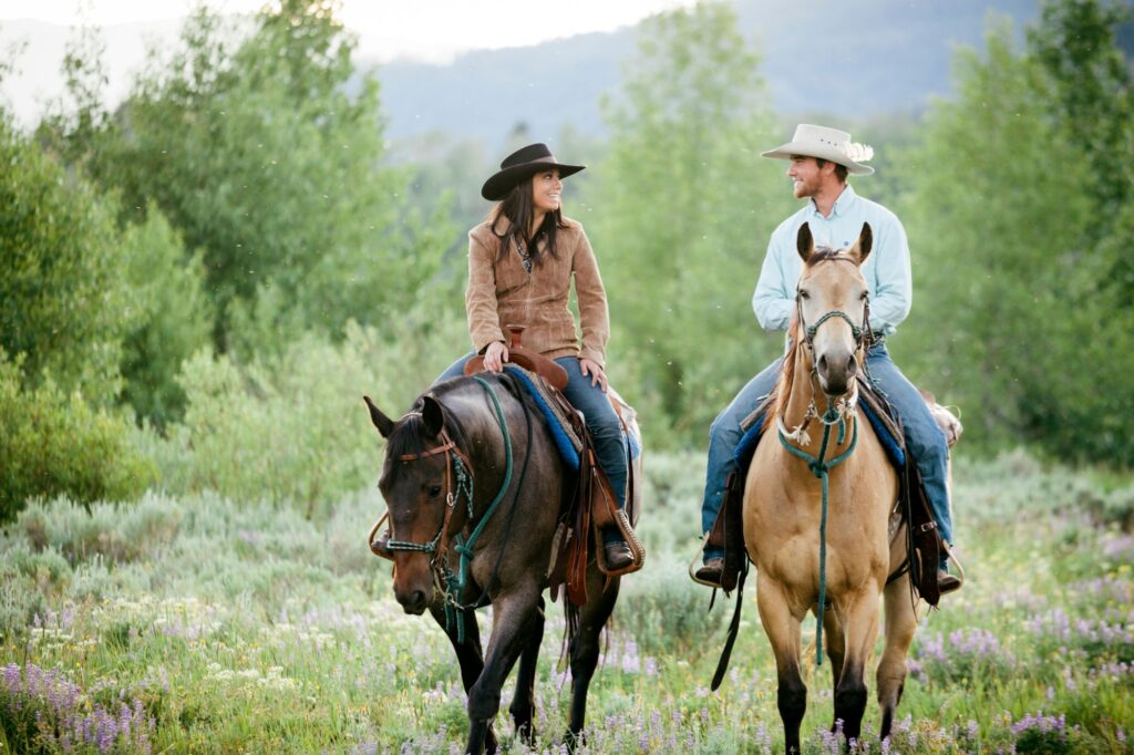 Couple riding horses in Big Sky Montana. This destination is one of the best vacation spots for couples in the U.S. 