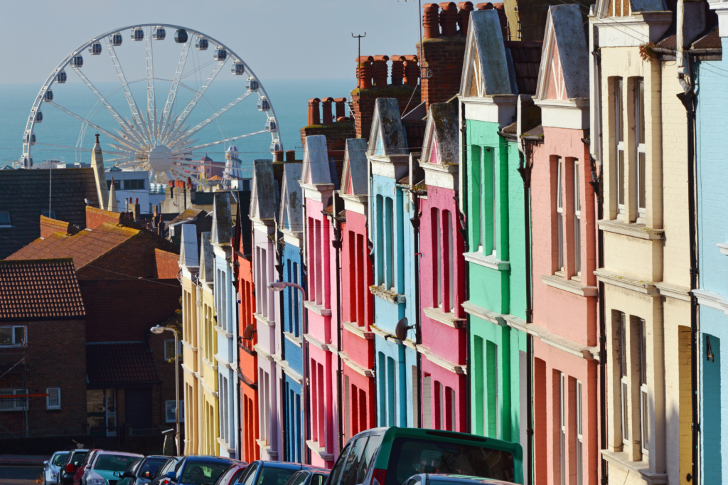 Colorful row of homes and ferris wheel in the background in Brighton, UK