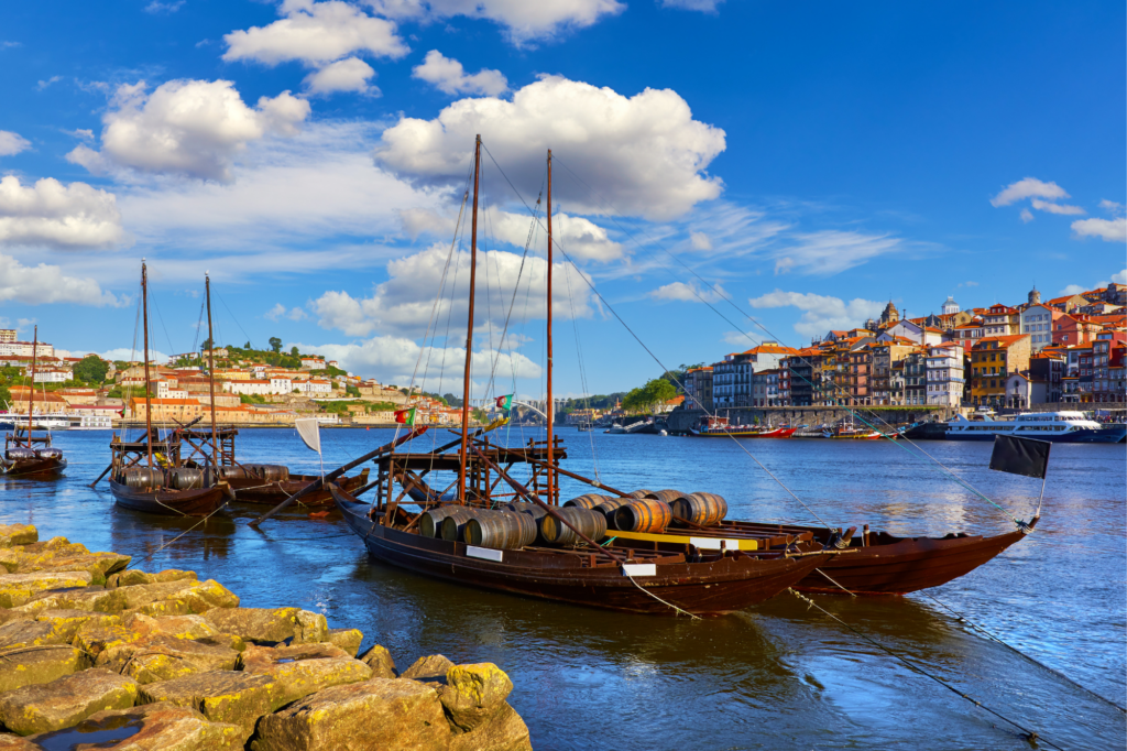 Boats on the river with city buildings in the background in Porto, Portugal.